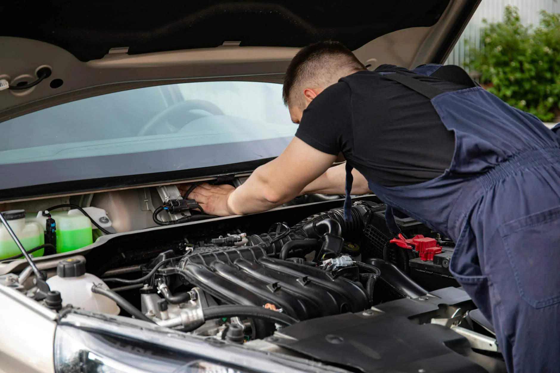 Auto mechanic performing engine maintenance on a car