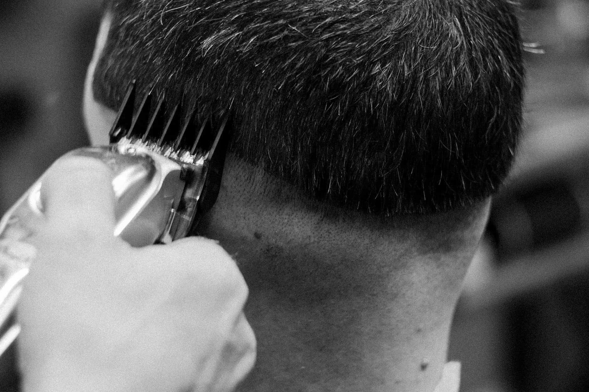 Barber giving a close clipper haircut in a classic barbershop