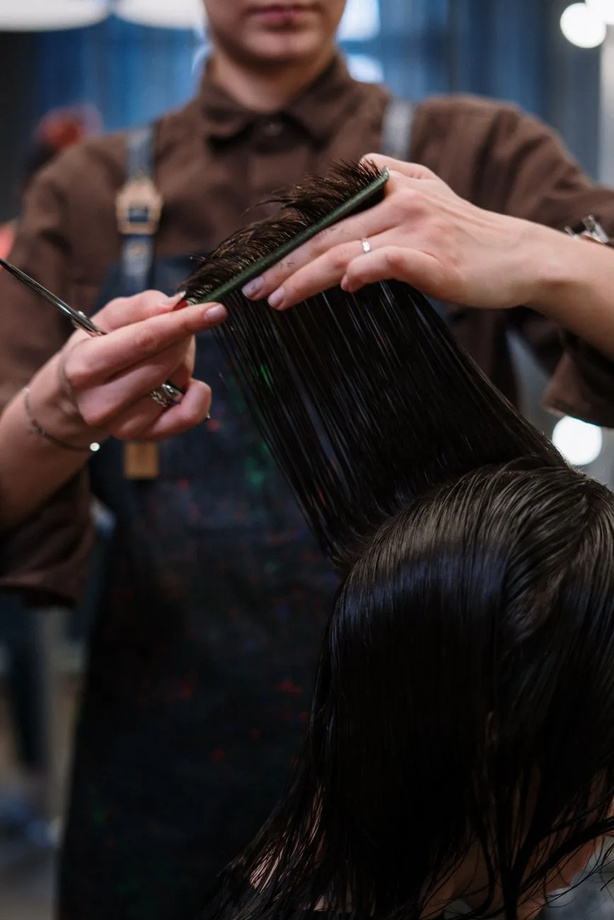 Hair stylist cutting a client's hair in a professional salon